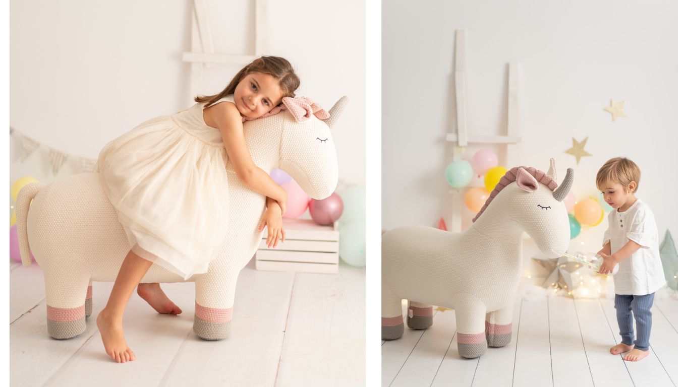 Amigurumi gigante de unicornio con niña encima