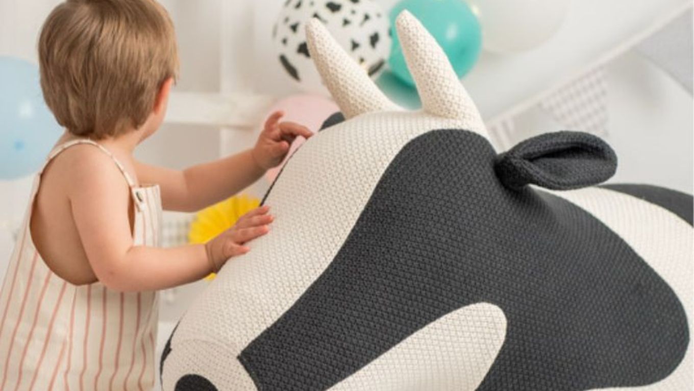 niño jugando Amigurumi gigante de vaca