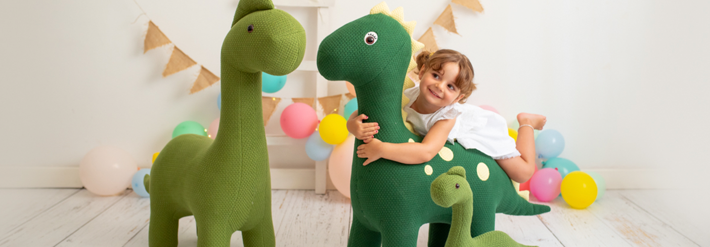 Niña jugando con amigurumis gigantes