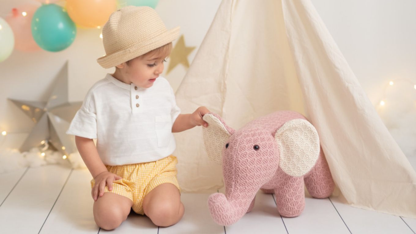 Niño jugando con un peluche de elefante