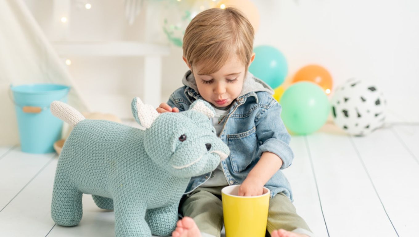 Niño jugando con un peluche de perro